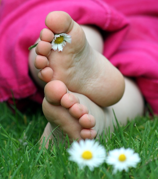 Kinderfüße mit Blumenwiese