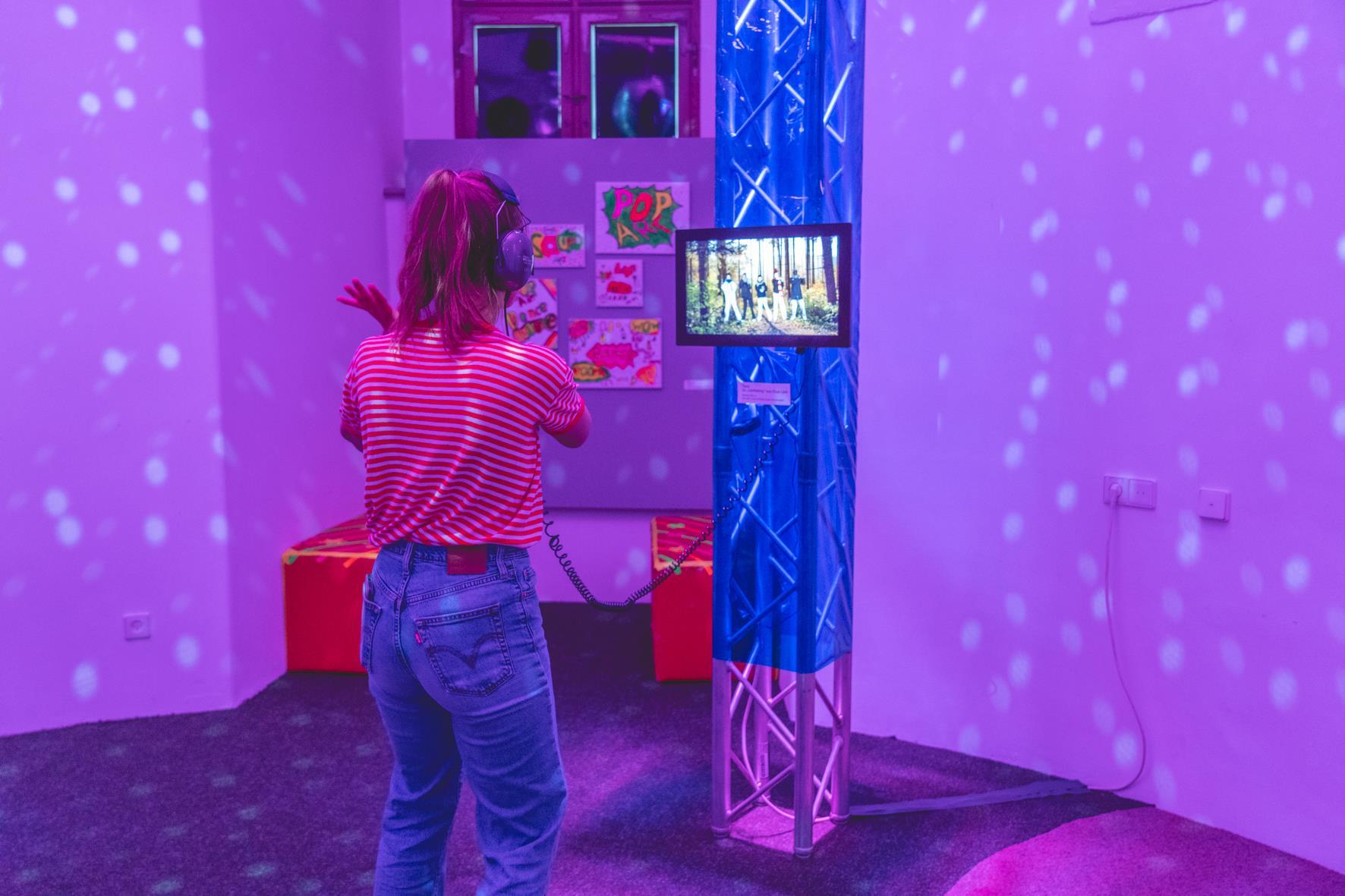 Ein Mädchen Tanz in der Ausstellung vor einem Bildschirm