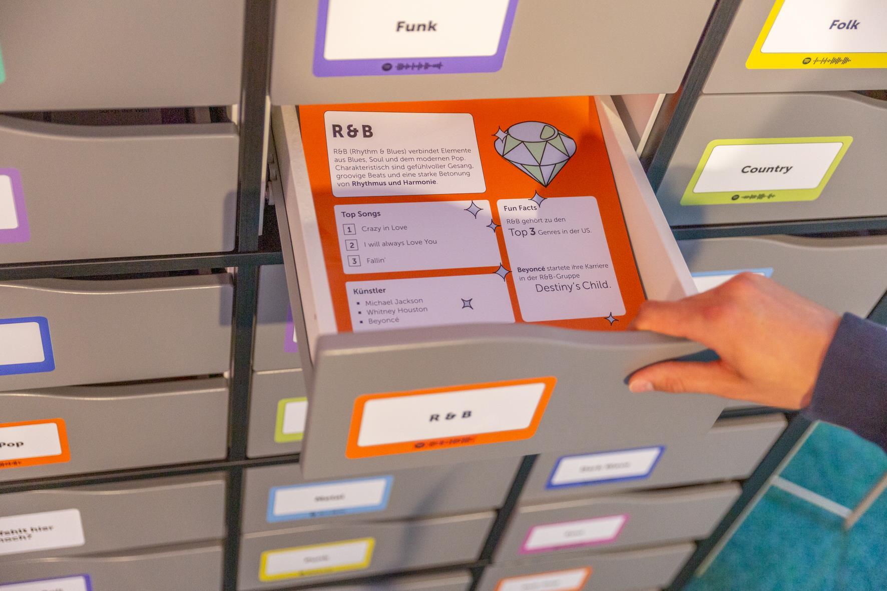 Eine geöffnete Schublade mit Informationszettel zu Musikstilen