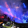 Tänzerinnen und Tänzer vor einer Bühne mit Discobeleuchtung