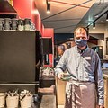 Mann mit Kaffeetasse in der Hand bedient im Hotel einsmehr