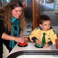 Junge Frau und Kind spielen mit einer elektrischen Rennbahn